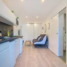 Petite cuisine moderne avec coin salon intégré.