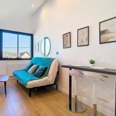 Salon moderne avec canapé et table haute.