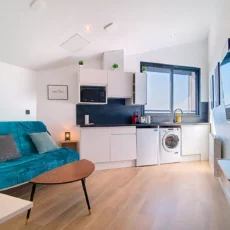 canape lit cuisine equipements complets location appartement court et long sejour argenteuil Salon moderne avec canapé et cuisine équipée.