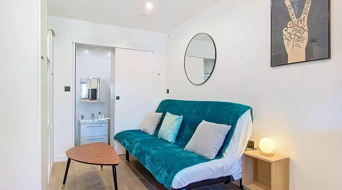 canape salle de bain apparente location appartement argenteuil Salon moderne et épuré avec canapé et miroir.