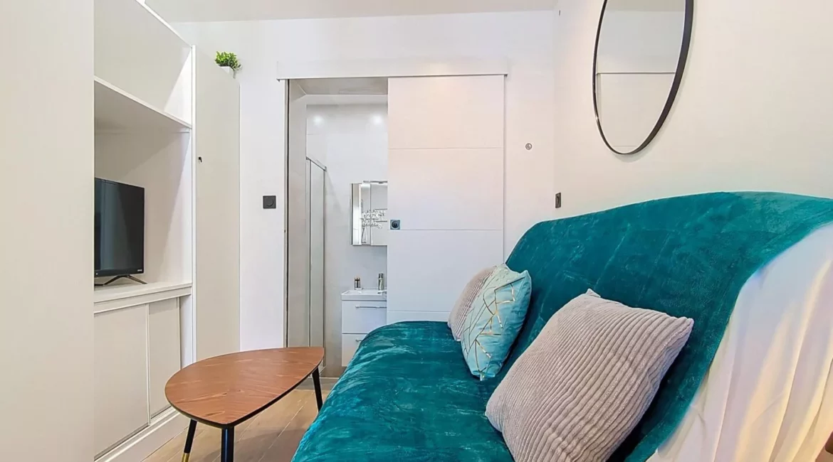 canape turquoise salle de bain location appartement argenteuil Salon moderne avec canapé turquoise et miroir rond.