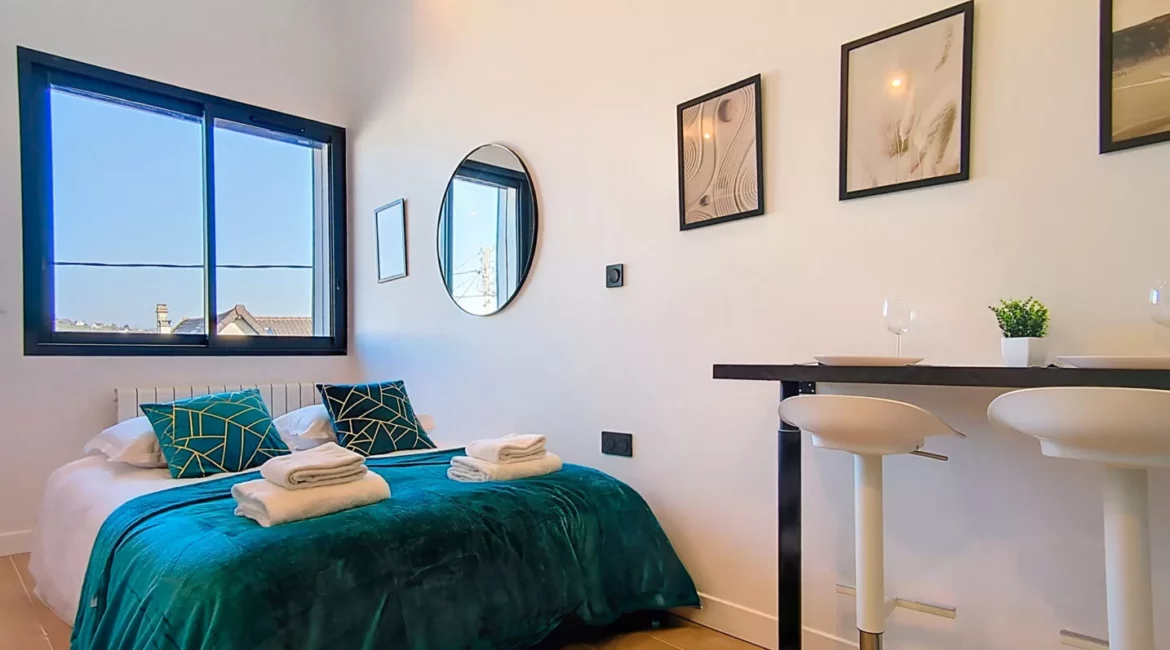 Chambre moderne avec lit double, lumières et table haute.