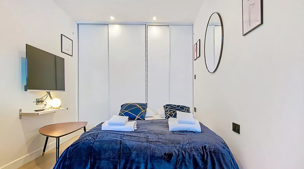 Chambre moderne avec lit et décoration minimaliste.