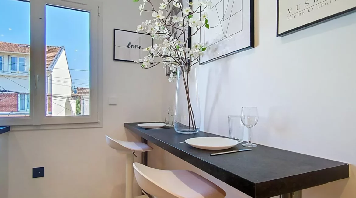 coin repas fenetre decoration location appartement argenteuil Coin repas moderne avec tabourets hauts et décoration florale.