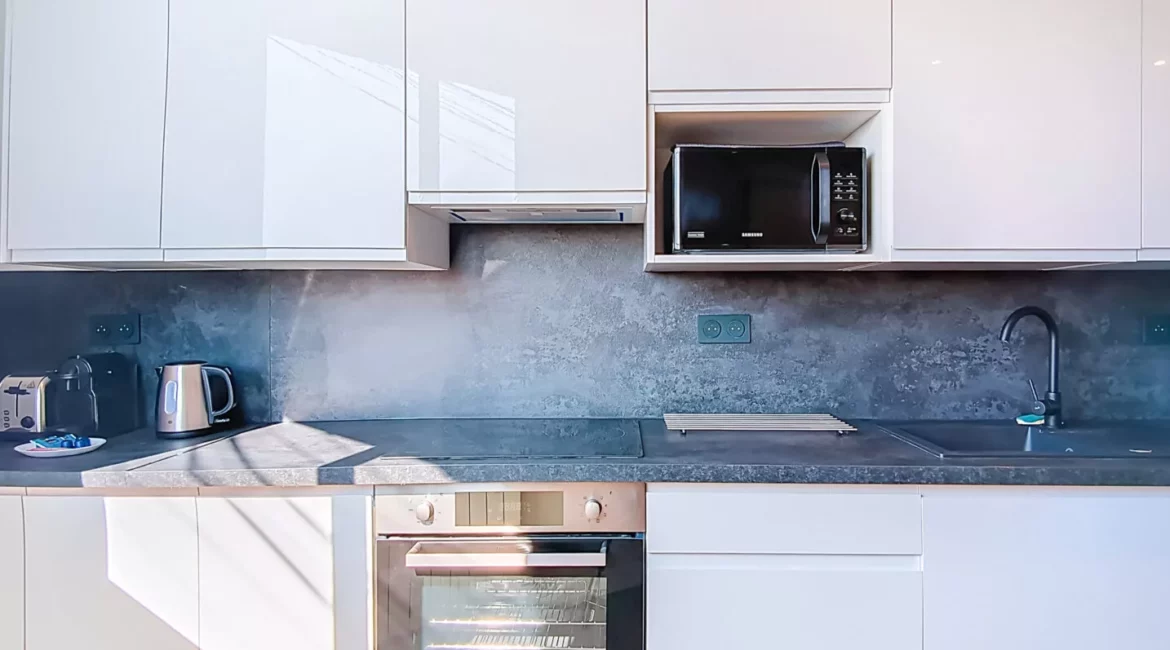 cuisine equipee location appartement court sejour argenteuil Cuisine moderne avec appareils électroménagers et plantes décoratives.