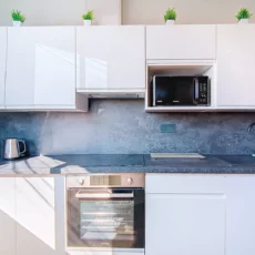 cuisine equipee location appartement court sejour argenteuil Cuisine moderne avec appareils électroménagers et plantes décoratives.