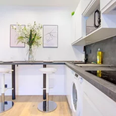 cuisine moderne avec bar et tabourets location appartement argenteuil Cuisine moderne avec tabourets et fleurs.