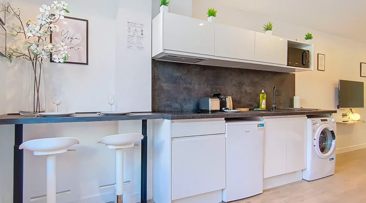 Cuisine moderne avec bar et appareils électroménagers.