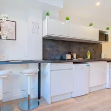 Cuisine moderne avec bar et appareils électroménagers.