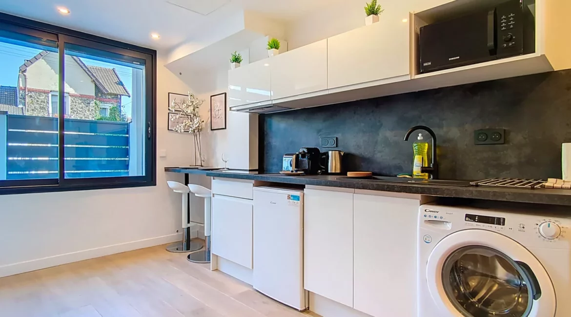 Cuisine moderne avec électroménager et fenêtre.