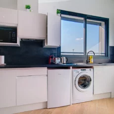 cuisine moderne lumineuse location appartement court et long sejour argenteuil Cuisine moderne avec fenêtres et lave-linge.