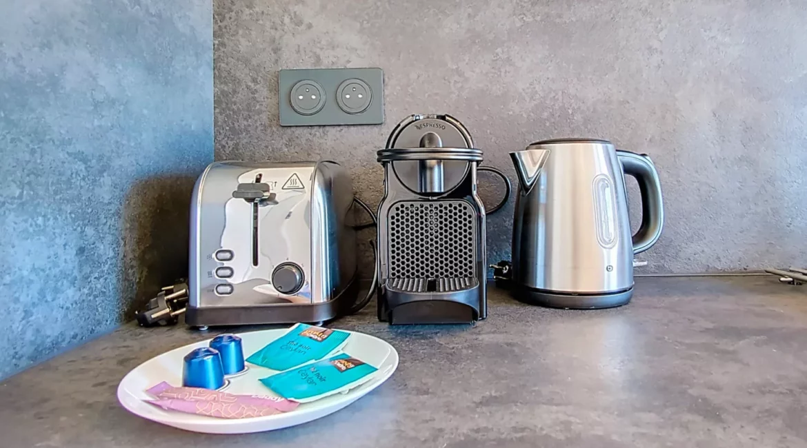 Cafetière, grille-pain et bouilloire sur le comptoir.