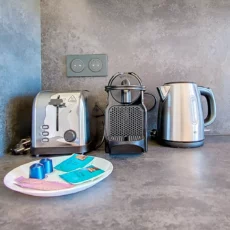 Cafetière, grille-pain et bouilloire sur le comptoir.