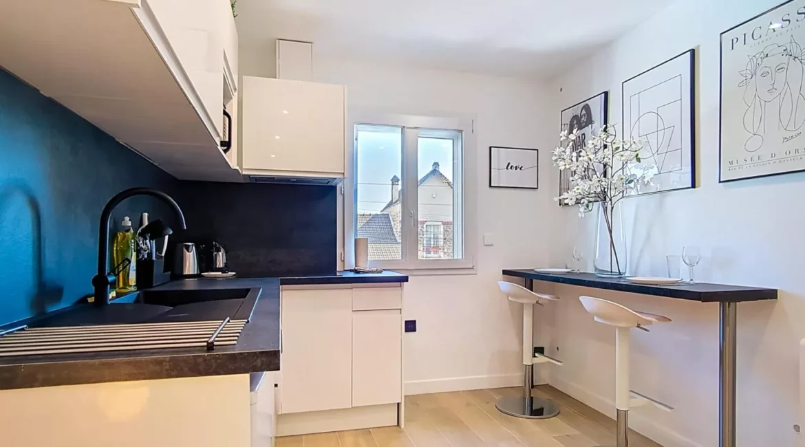 plan large cuisine salon location appartement argenteuil Cuisine moderne avec table haute et chaises blanches.