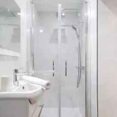 salle de bain moderne avec douche et lavabo location appartement argenteuil Petite salle de bain moderne avec douche vitrée.