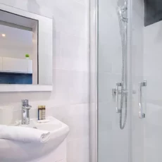 Salle de bain moderne avec douche et lavabo.