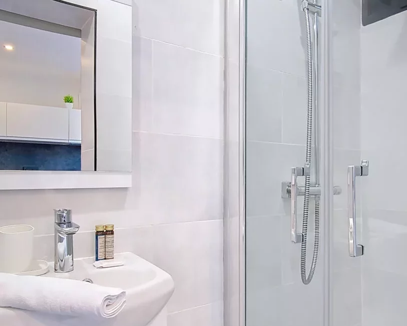 Salle de bain moderne avec douche et lavabo.