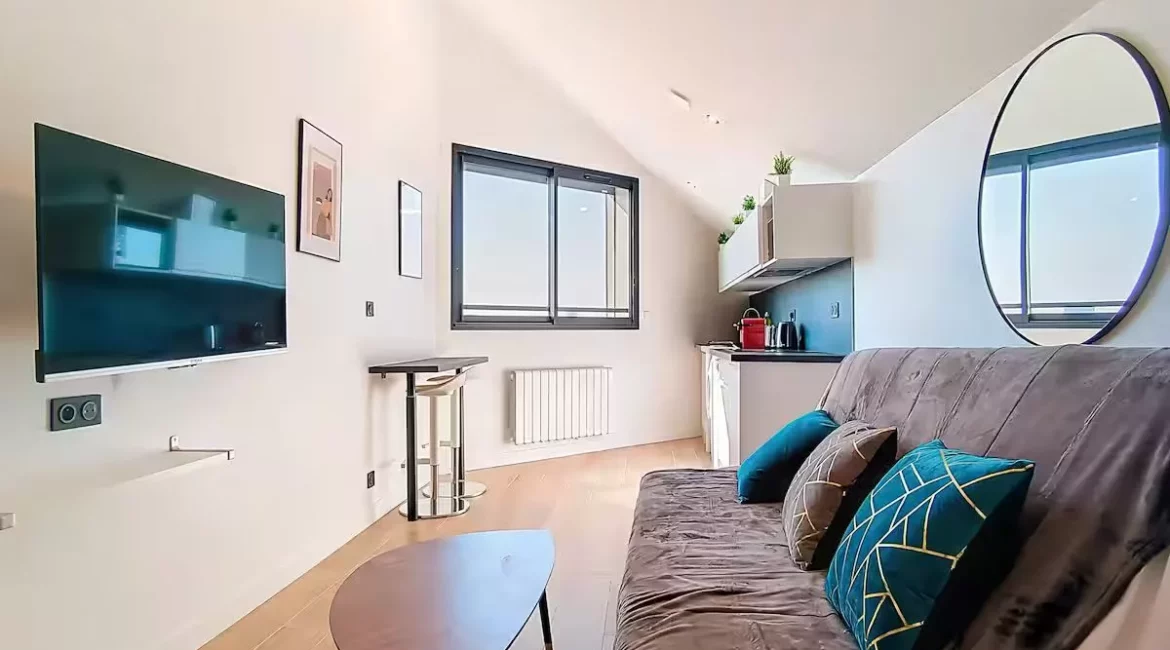 salle de bain moderne location appartement court et long sejour argenteuil Salon moderne avec canapé et télévision murale.