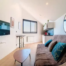 salle de bain moderne location appartement court et long sejour argenteuil Salon moderne avec canapé et télévision murale.
