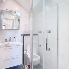 Salle de bain moderne avec douche vitrée.