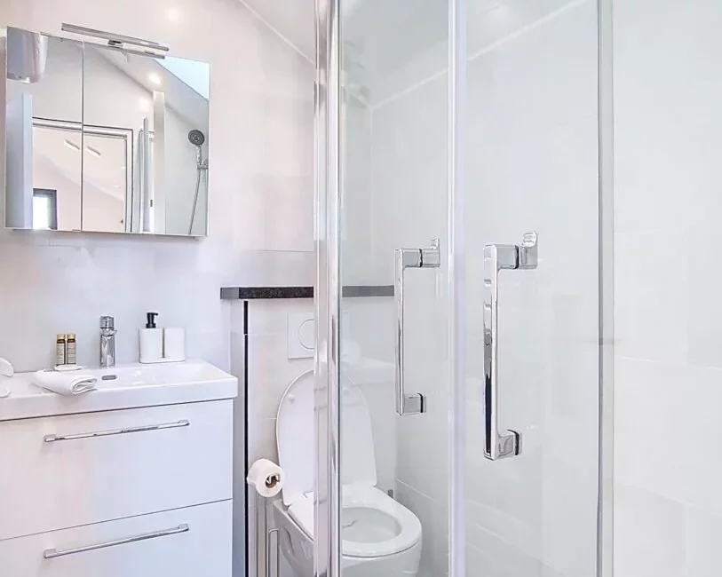 Salle de bain moderne avec douche vitrée.