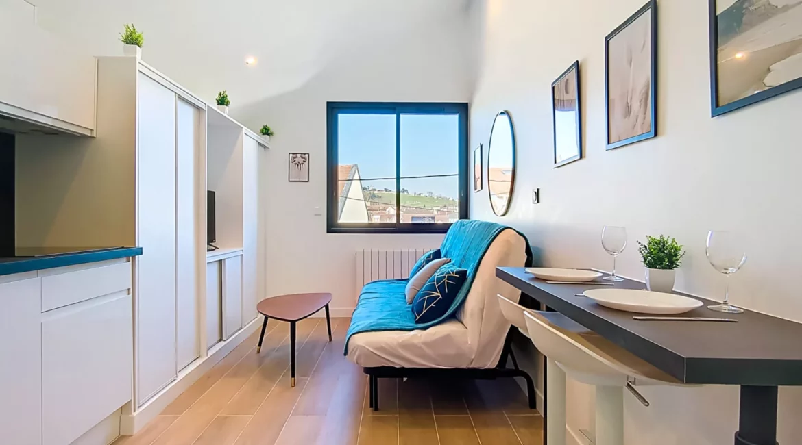 Petit salon moderne avec canapé et table à manger.