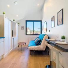 Petit salon moderne avec canapé et table à manger.