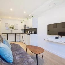 salon moderne avec canapé et télé location appartement argenteuil Salon moderne avec cuisine et canapé gris.