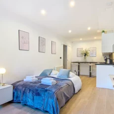 studio moderne avec lit, cuisine et décoration minimaliste location appartement argenteuil Studio moderne avec lit et cuisine équipée.