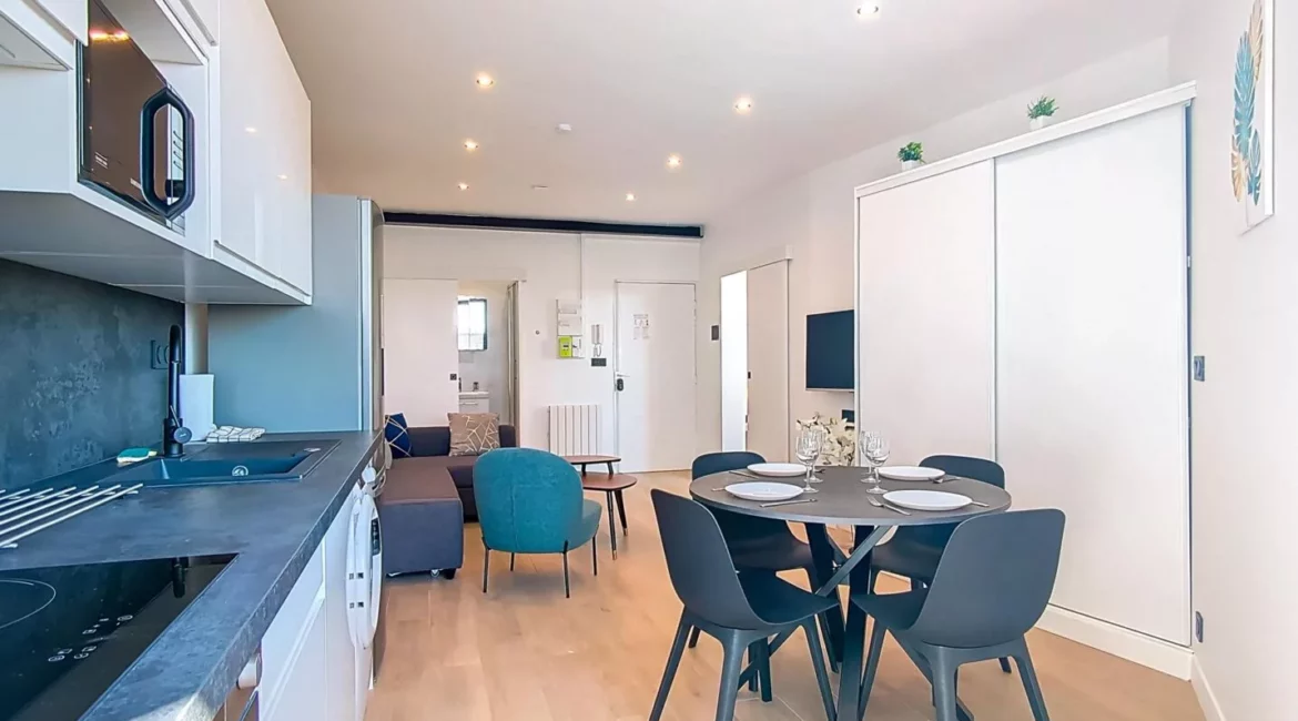 vue globale cuisine sejour location appartement court sejour argenteuil Cuisine-salon moderne avec coin repas circulaire.