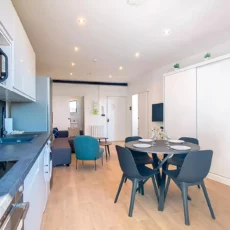 vue globale cuisine sejour location appartement court sejour argenteuil Cuisine-salon moderne avec coin repas circulaire.