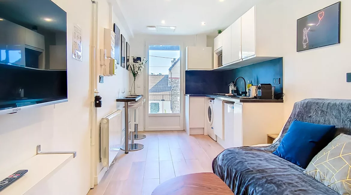 vue salon cuisine location appartement argenteuil Salon moderne avec cuisine intégrée et canapé.