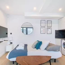 Studio moderne avec lit et cuisine intégrée.