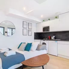 Studio moderne avec kitchenette et lit.