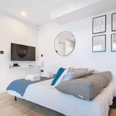Chambre moderne avec lit, télé et décor minimaliste.