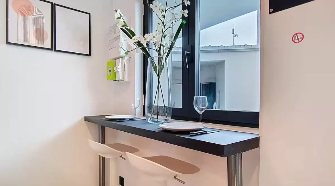 Coin-repas minimaliste avec fenêtre et décorations murales.