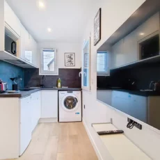 cuisine location studio voyage argenteuil Cuisine moderne avec électroménagers et télévision murale.