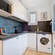 cuisine studio voyage argenteuil Cuisine moderne avec électroménagers et fenêtre ouverte.