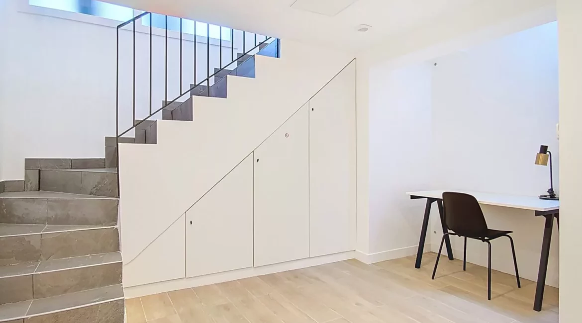 Sous-sol moderne avec escalier et bureau minimaliste.