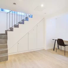 Sous-sol moderne avec escalier et bureau minimaliste.