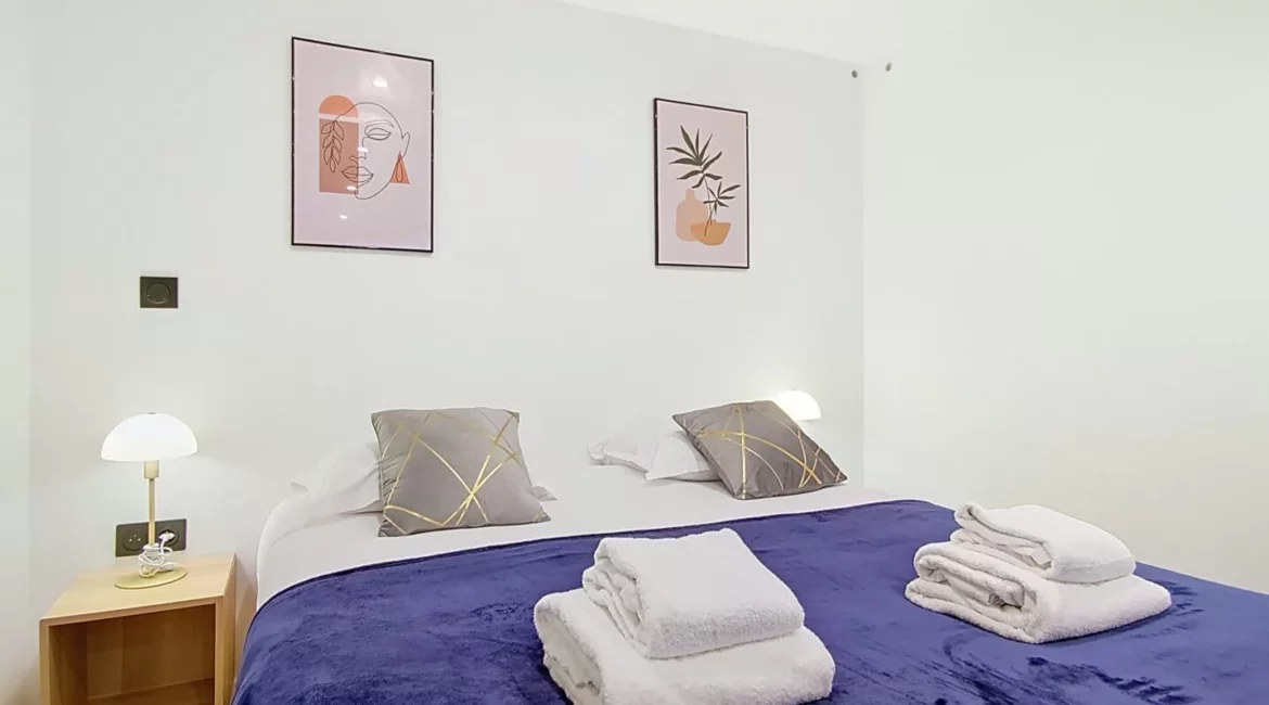 Chambre moderne avec lit double et décor minimaliste.