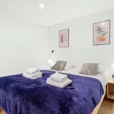 Chambre moderne avec lit double et décoration murale.