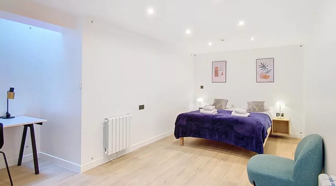 Chambre moderne avec lit double et bureau.