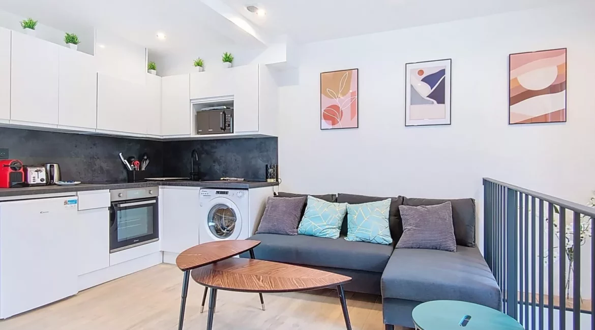 Salon moderne avec cuisine ouverte et canapé.