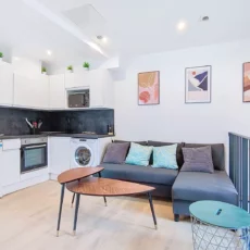 Salon moderne avec cuisine ouverte et canapé.