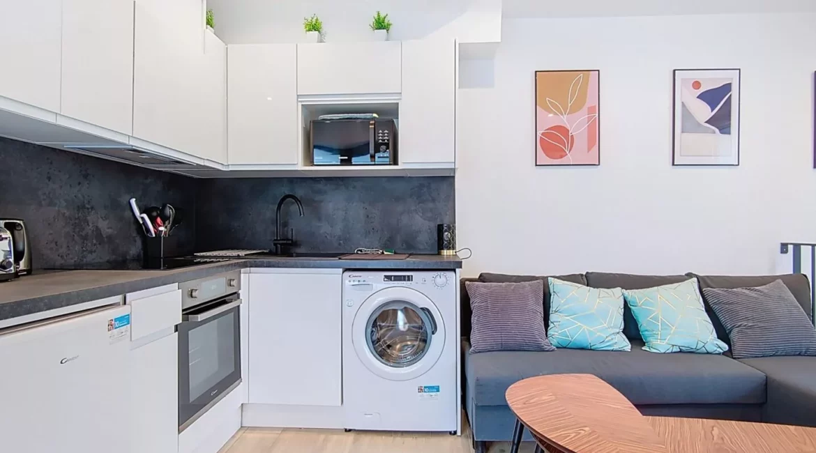 Cuisine moderne avec canapé et décoration murale.