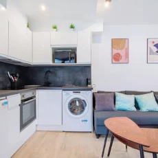 Cuisine moderne avec canapé et décoration murale.