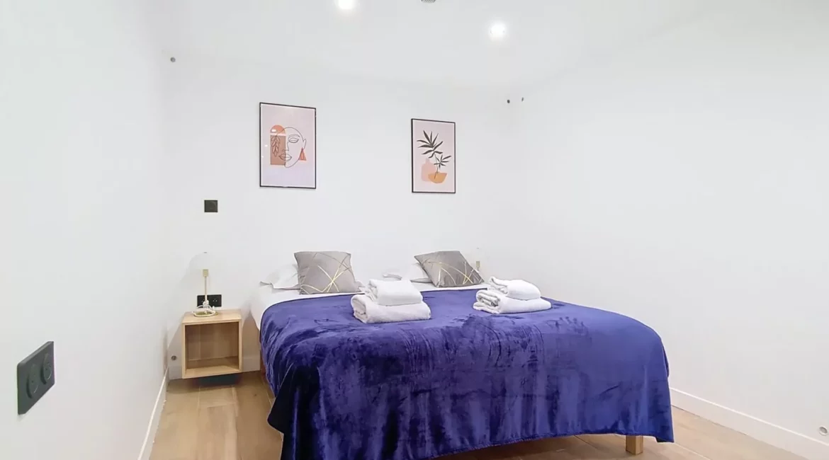 Chambre moderne avec lit double et décoration murale.