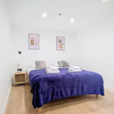 Chambre moderne avec lit double et décoration murale.