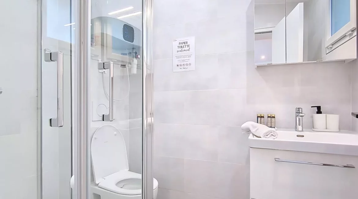 Salle de bain moderne avec douche et lavabo.